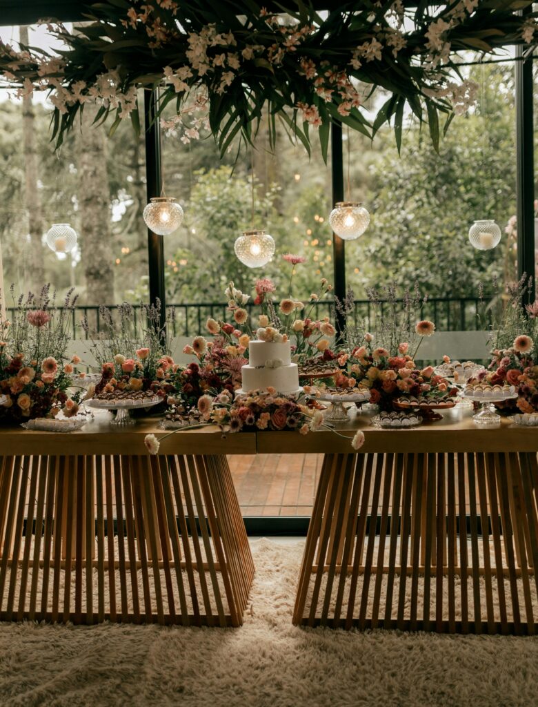 A beautifully decorated wedding table with flowers and a cake inside a stylish venue.